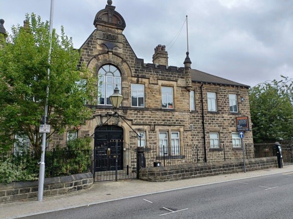 Front of stone building with wrought iron railings and gate.